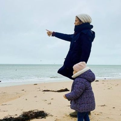 Both are wearing heavy clothes while mother is pointing to something.